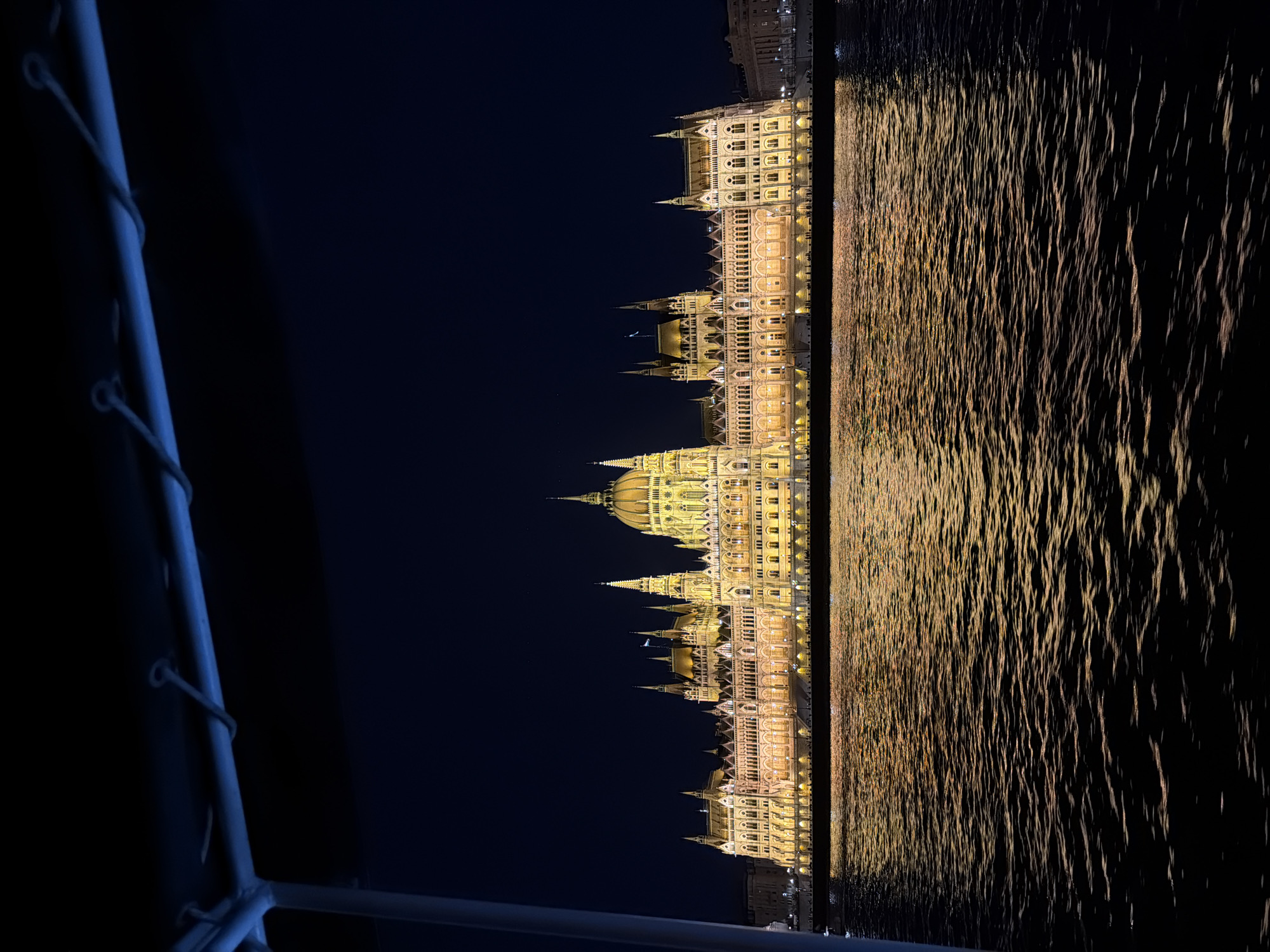 Budapest Parliament Building illuminated at night along Danube River