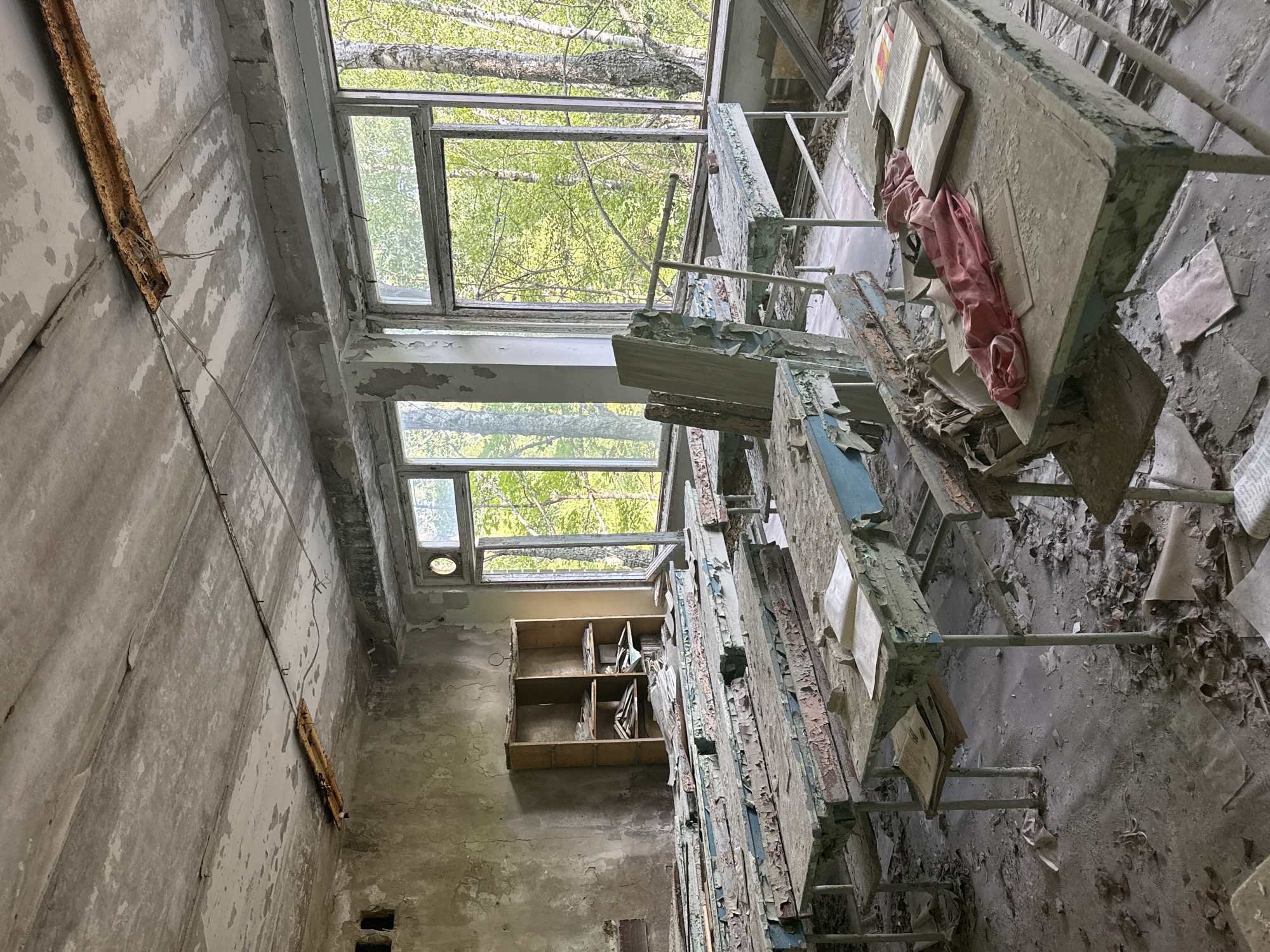 Inside an abandoned building: decayed classroom and cluttered workshop