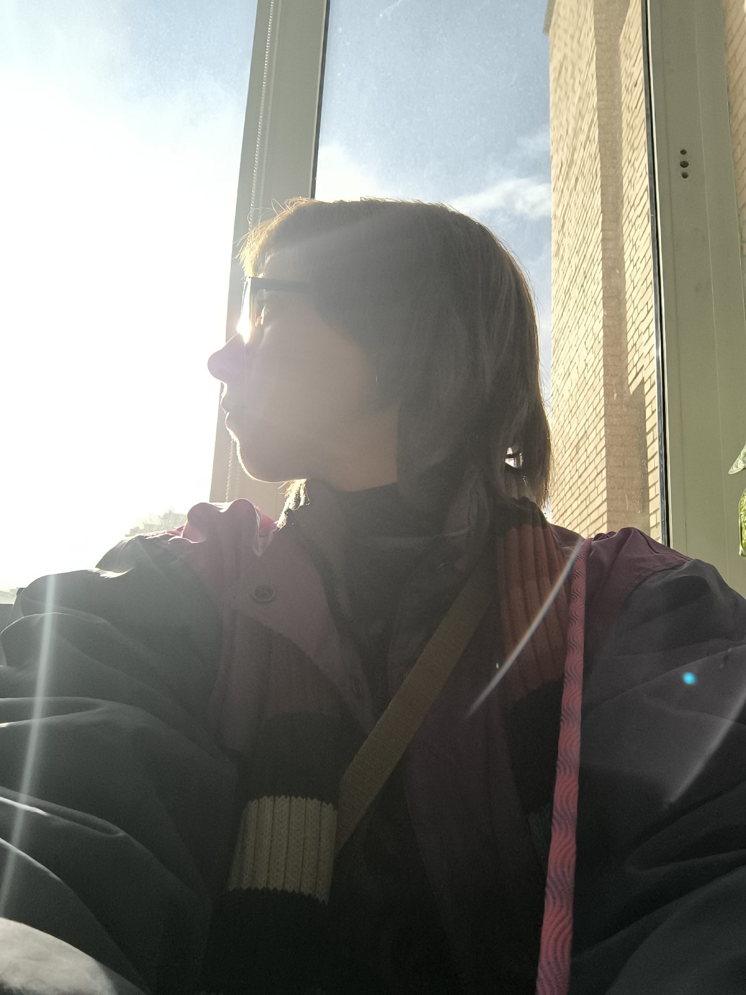 Person observes Moscow cityscape from window on sunny afternoon