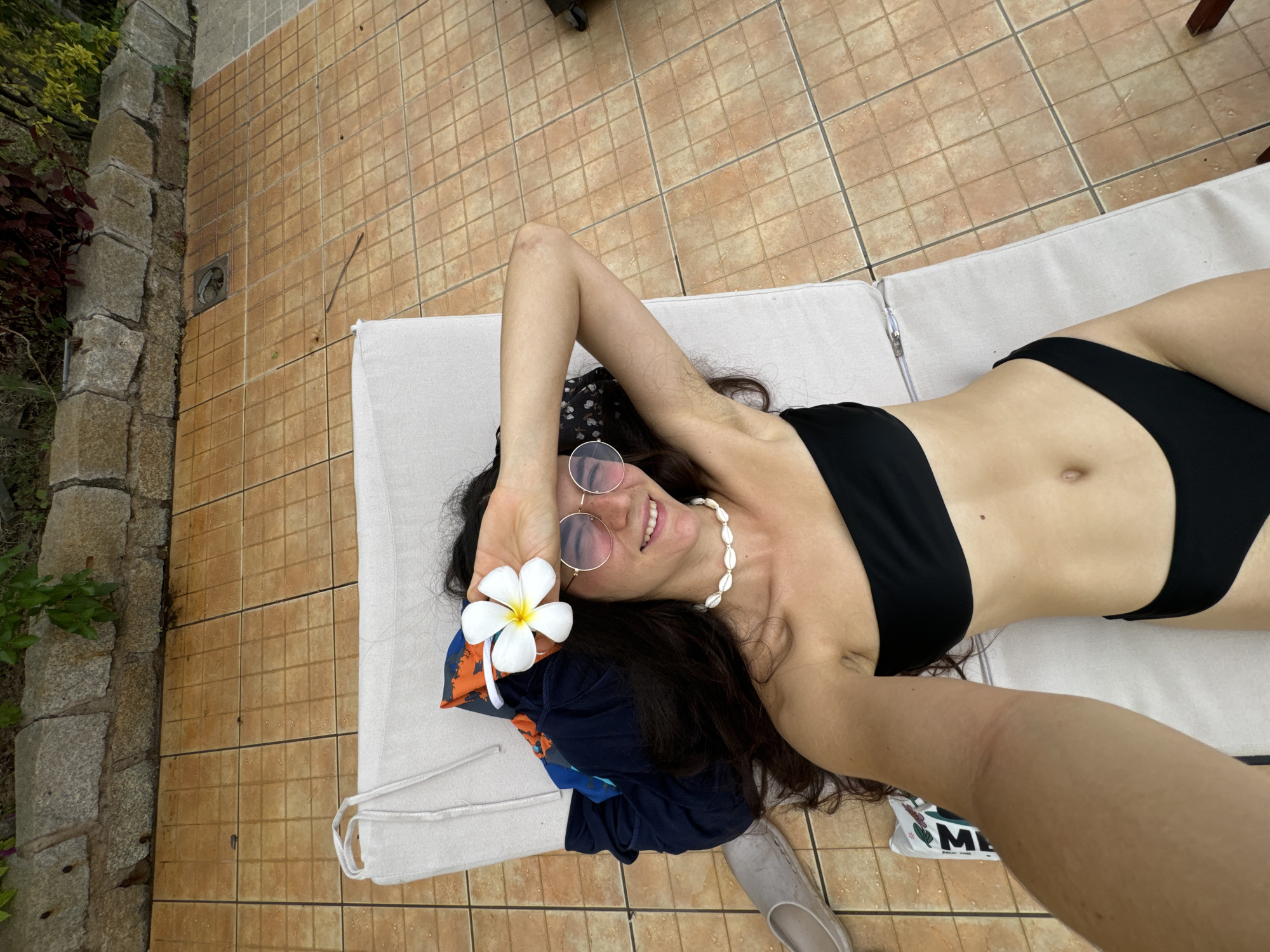 Woman enjoys poolside relaxation at Vietnamese tropical resort