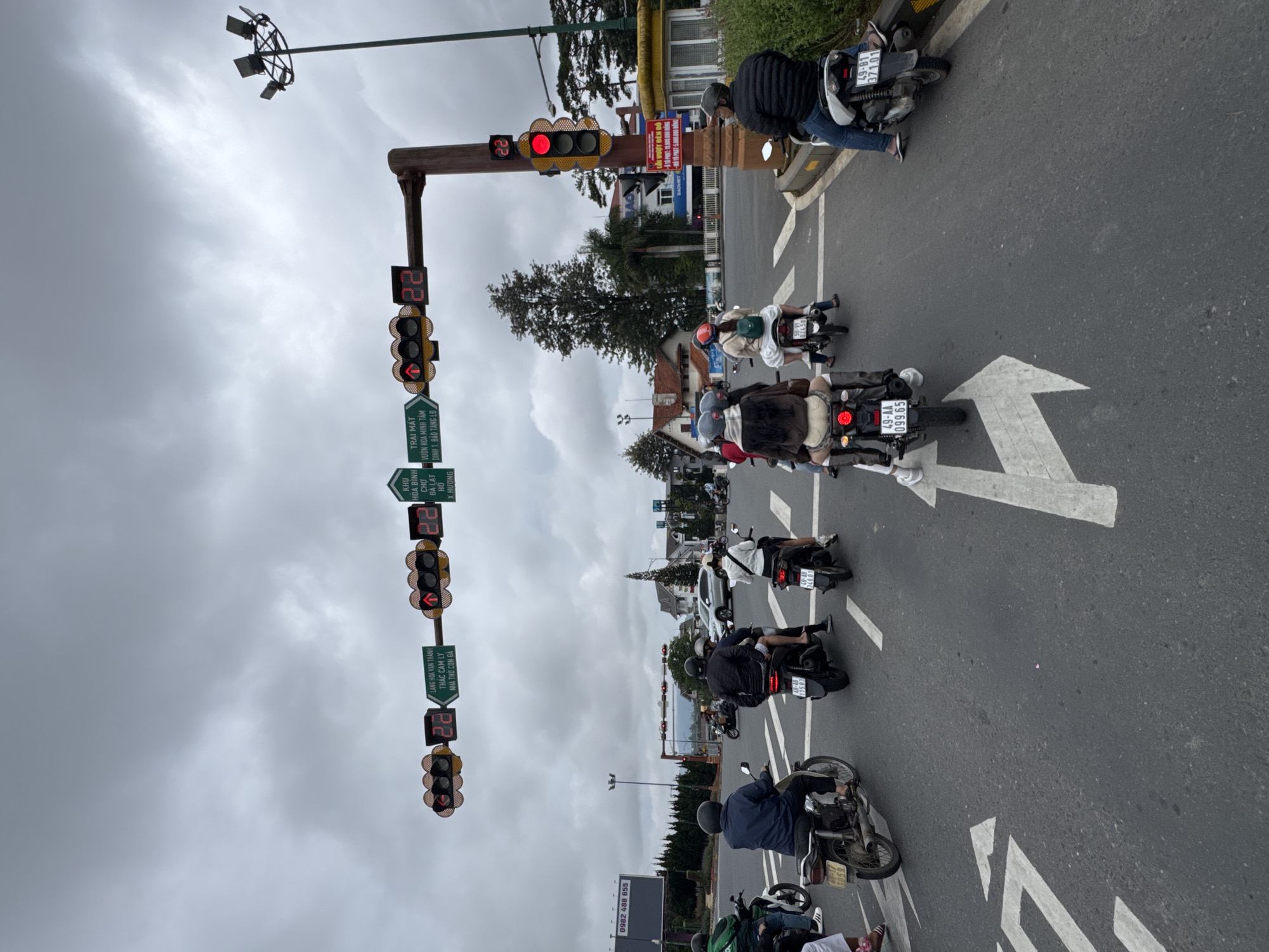 Motorcycle traffic at a Da Lat intersection on a cloudy day