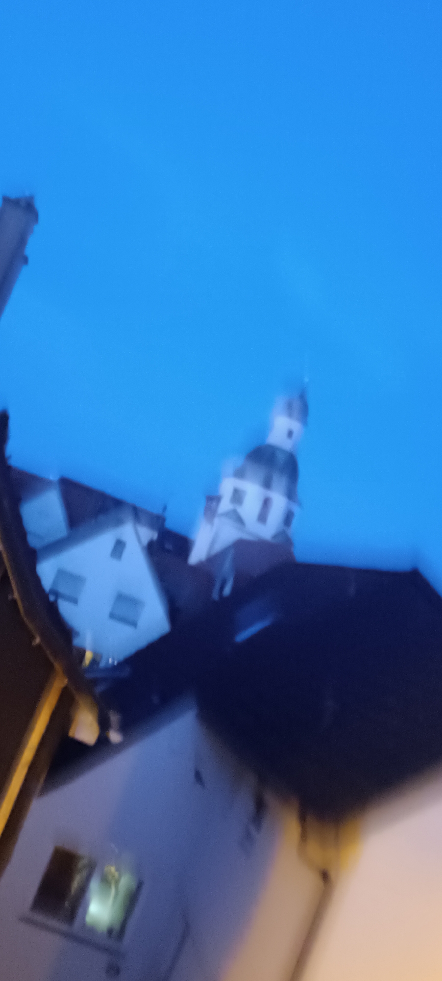 Winnenden church tower at twilight, shot through a metal fence