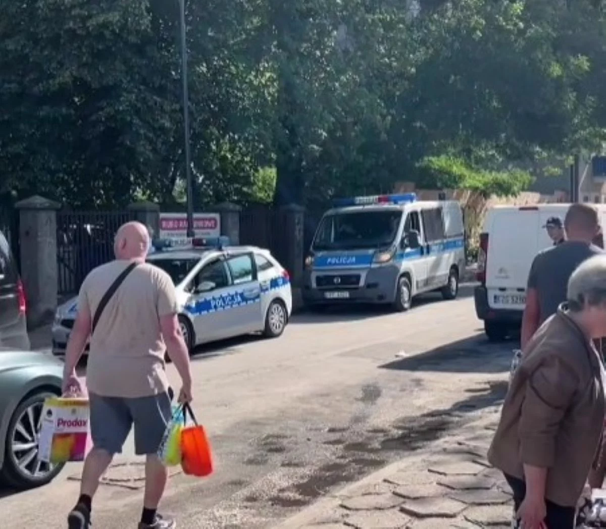 Policja na Rynku Bałuckim. Radiowozy na sygnale wśród mieszkańców robiących zakupy