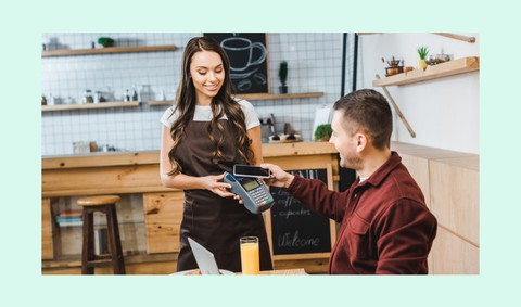 Membre de l'équipe Payhawk payant le petit déjeuner avec une carte d'entreprise avant une réunion