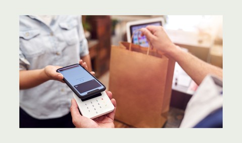 Mujer Pagando en una tienda Con la tarjeta de cashback de Payhawk para gastos de empresa