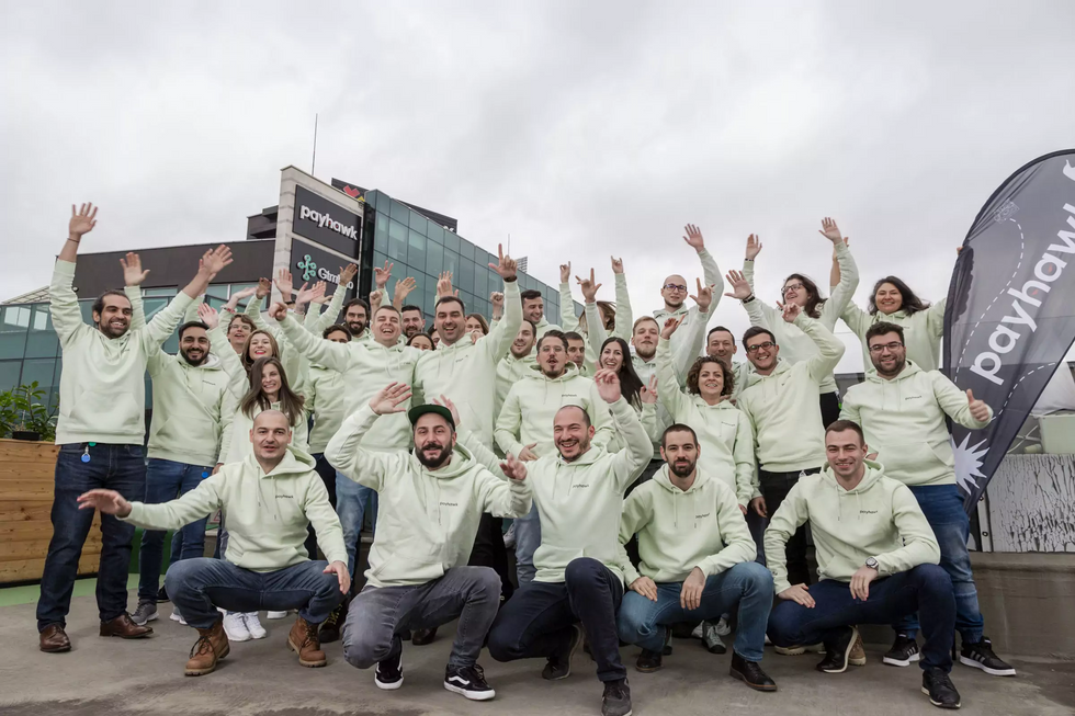 Payhawk team posing in front of our main office. 