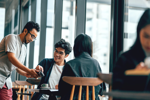 Employee paying for coffee during a business trip