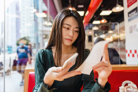 Employee checking the bill to pick the expenses, that are coverred by her corporate expense policy