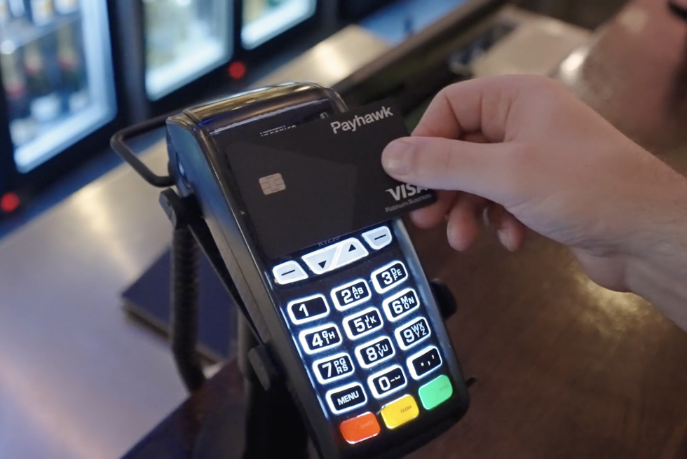 Employee paying with Payhawk's Corporate Credit Card at the counter