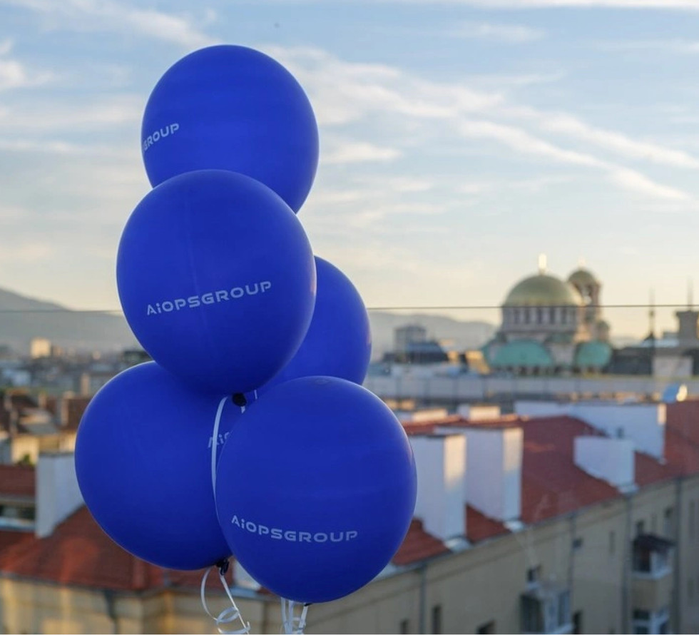 Ballons avec logo AIOPS, célébrant d'avoir économisé deux heures par jour sur la gestion des dépenses avec Payhawk