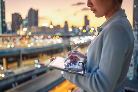 Een vrouw leest een artikel over de evolutie van de financiële functie op een tablet.