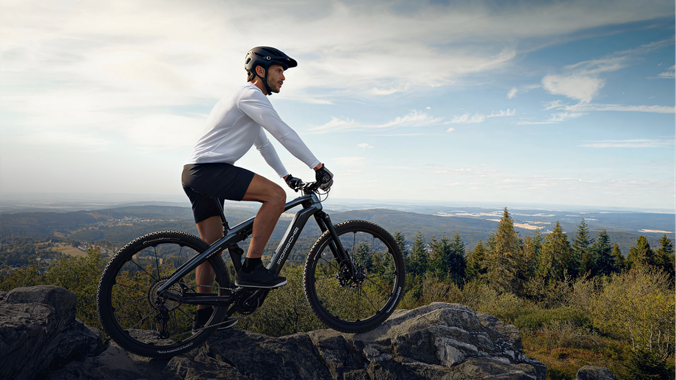 A biker riding a Porsche eBike on a mountain trail