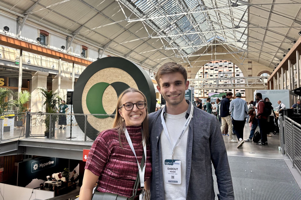 Two members of the Payhawk Partner team at DafTech 2026 at Le 104 in Paris, smiling in front of the Pennylane logo