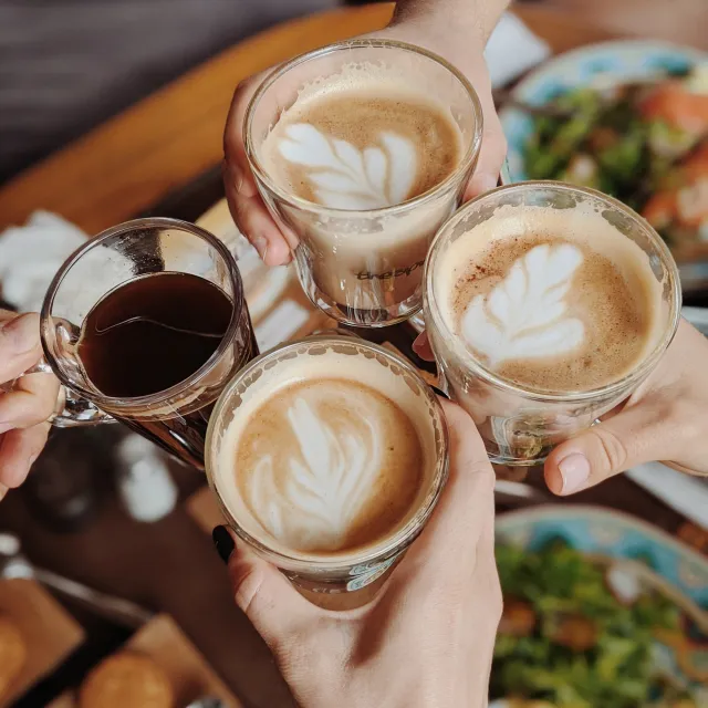 Tableware and various coffee drinks set up in a warm, inviting setting, associated with Lisa from Pilates by Lisa.