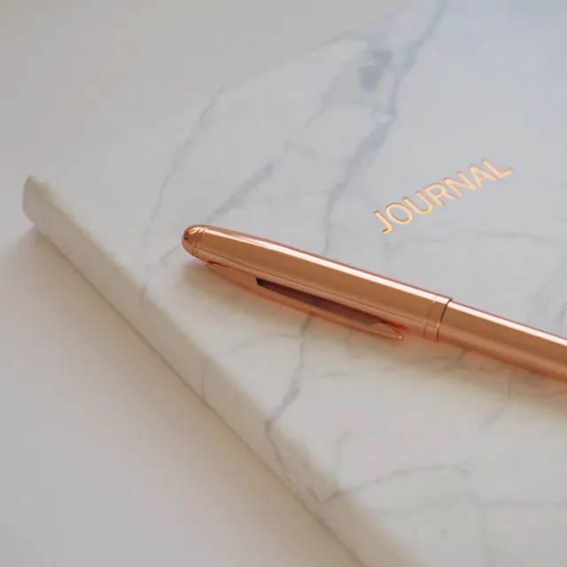 A stylish copper-toned pen from Pilates by Lisa, highlighting the elegance of the studio's accessories.