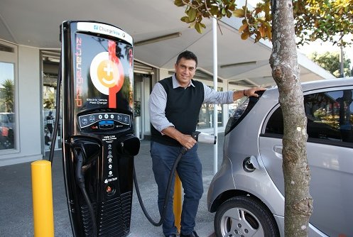 Mayor Mike Tana using a vehicle charging station.