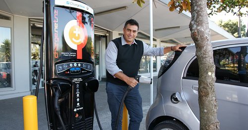 Mayor Mike Tana using a vehicle charging station.