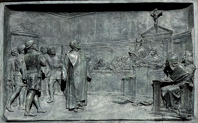 Reliéf znázorňující inkviziční proces z pomníku Giordana Bruna "Relief Bruno Campo dei Fiori n1" od Jastrow – Vlastní dílo (own picture). Licencováno pod Public domain via Wikimedia Commons.