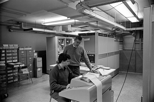 Tom Kurtz (stojící) a Michael Busch, spoluprogramátor DTSS, s GE-225 mainframe v pozadí, zdroj: Adrian N. Bouchard / Dartmouth College via Time