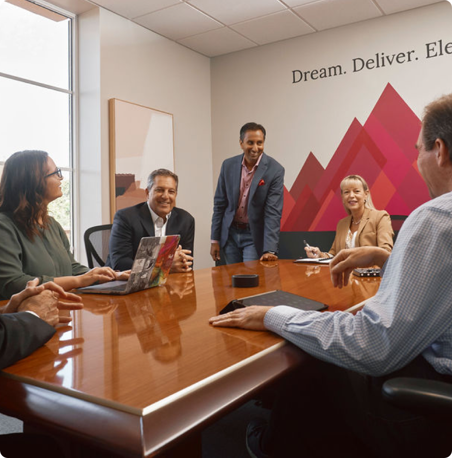 PeakActivity leadership seated around a conference table smiling. 