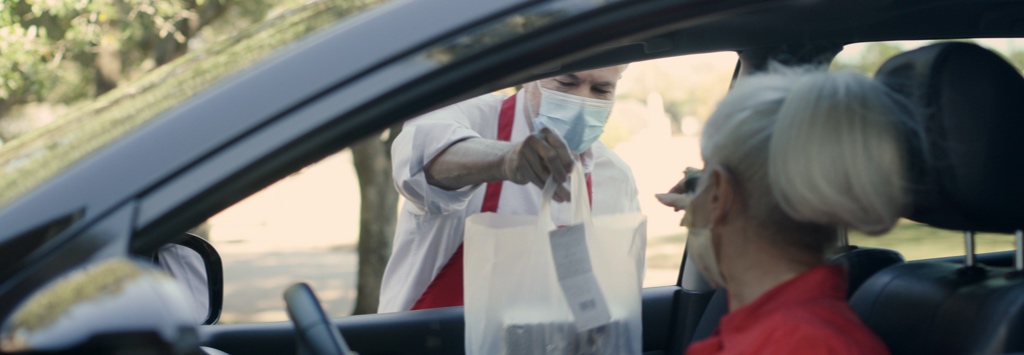 Elderly woman picking up food with curbside pickup