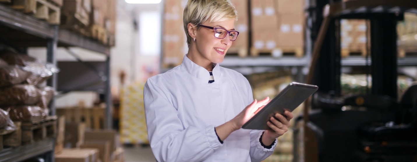 Retail worker keeping track of product catalog on tablet in warehouse