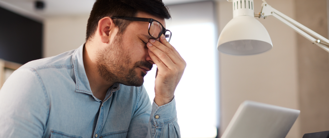 Frustrated businessman rubbing the bridge of his nose