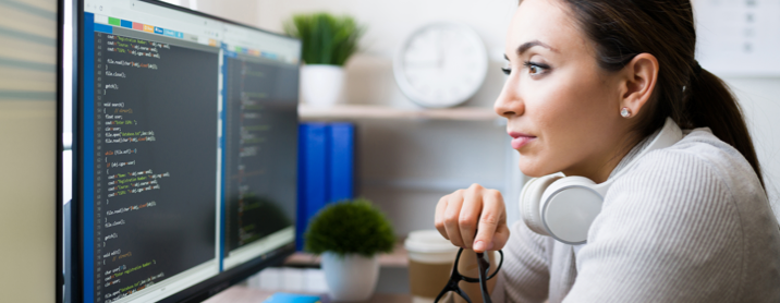 Female developer sitting at her desk reviewing her code