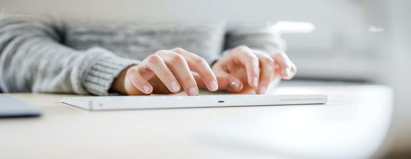 Close up of hands typing on keyboard