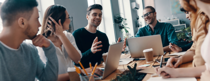 Group of coworkers sitting around a table having a brainstorming discussion