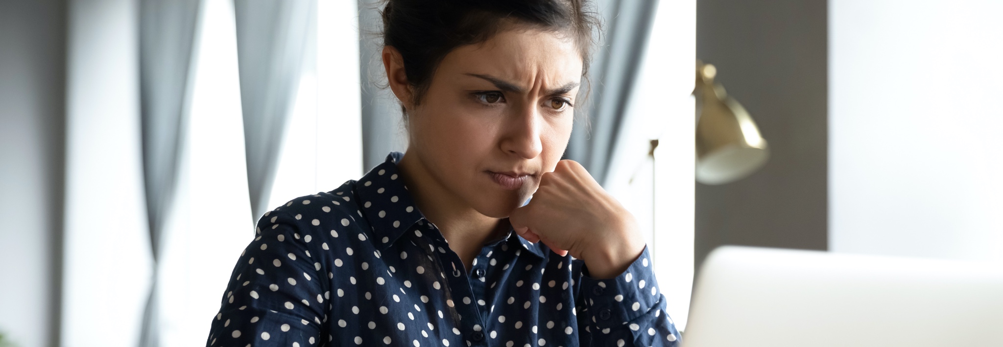 Young woman frustrated by emails on her laptop