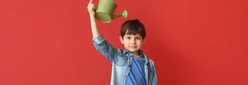 Young boy watering himself hoping he will grow tall