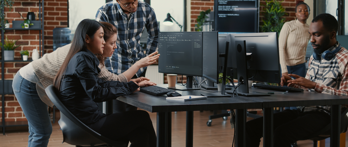 Group of software engineers working around a shared work desk. 