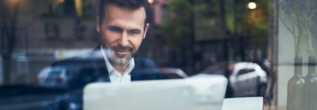 Happy man browsing B2B content in coffee shop