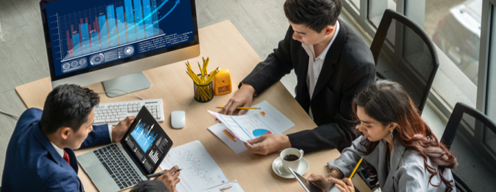 Group of data analysts sitting at a table and reviewing sales data