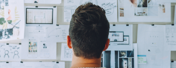 Man looking at a bulletin board with design inspiration planning on it