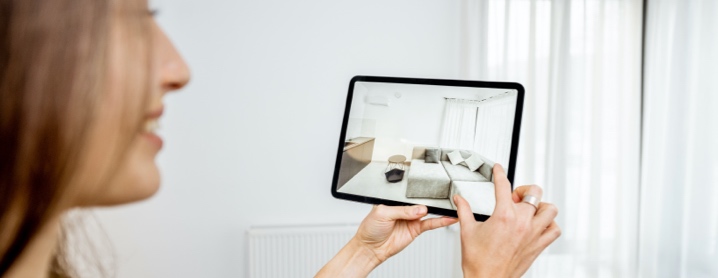 Young woman using augmented reality to see how furniture fits in her living room