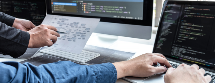 Close up shot of two software engineers working on implementing a new architecture