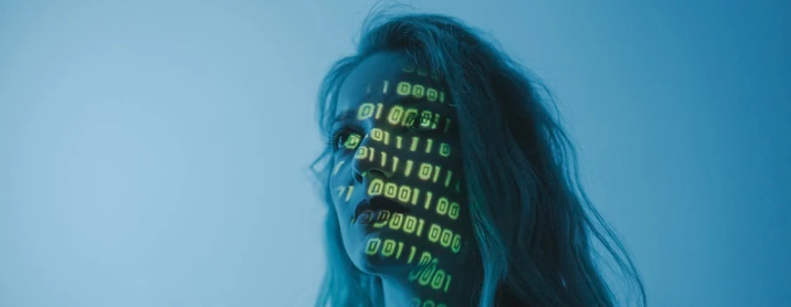 Woman standing in front of a screen with code projected onto it