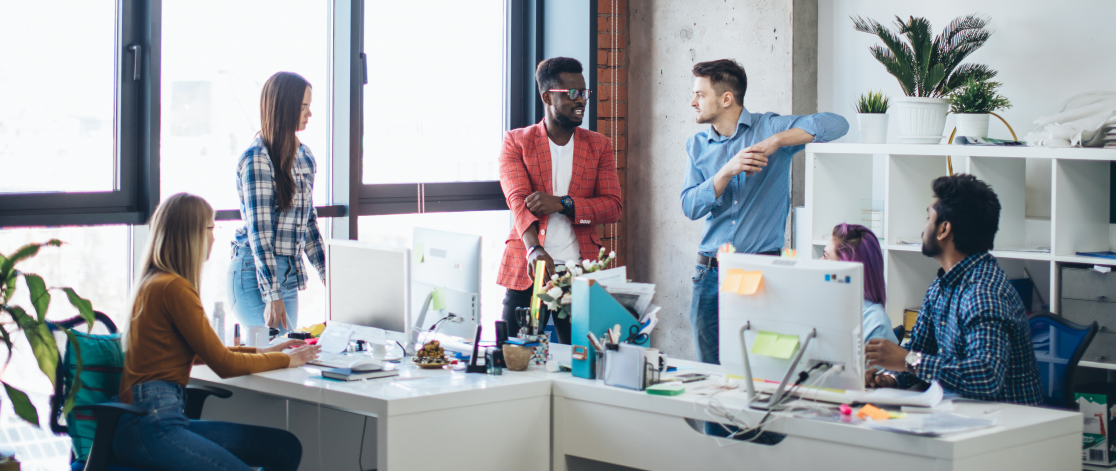 Meeting between engineers and business analysts in an open plan office