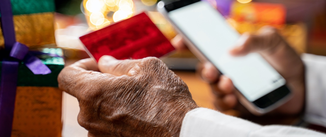 Elderly Man Buying Present on His Mobile Phone with Credit Card