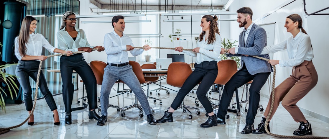 Two different marketing teams playing tug of war in office