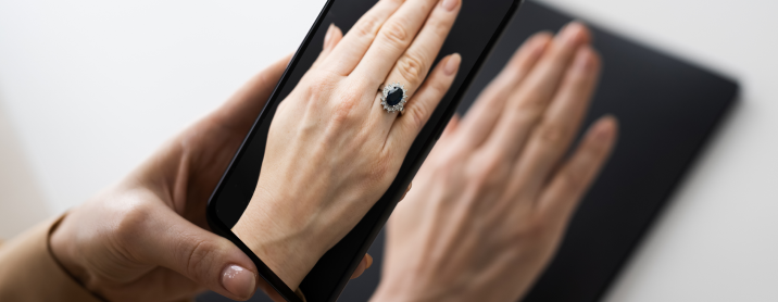 Woman holding a phone using AR to try on a ring