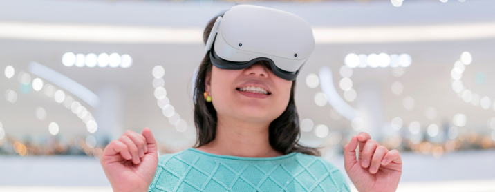 Happy young woman wearing VR goggles in a shopping mall