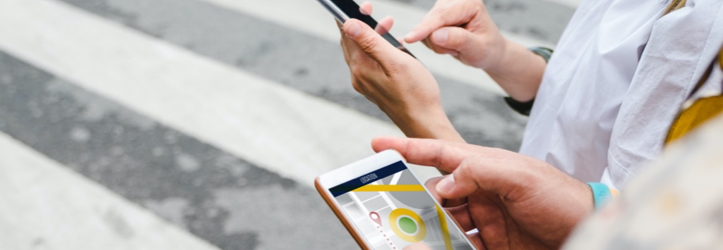 Two people using mobile GPS application while crossing street