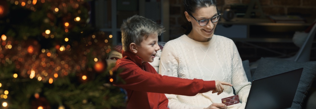 Mother and son browsing eCommerce website on couch next to a Christmas tree