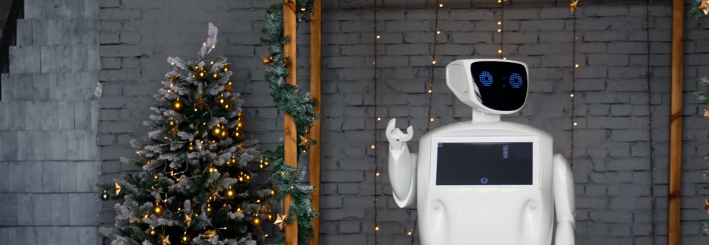 Friendly robot waving in front of Christmas tree