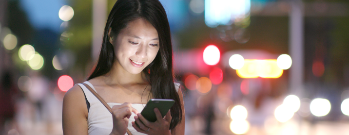 Young woman checking text messages on her mobile phone