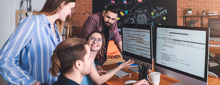 Team of engineers having a code review session at a cluster of desks