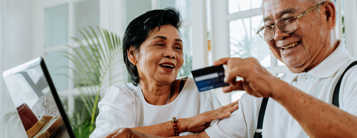 Elderly couple smiling playfully together after buying presents online